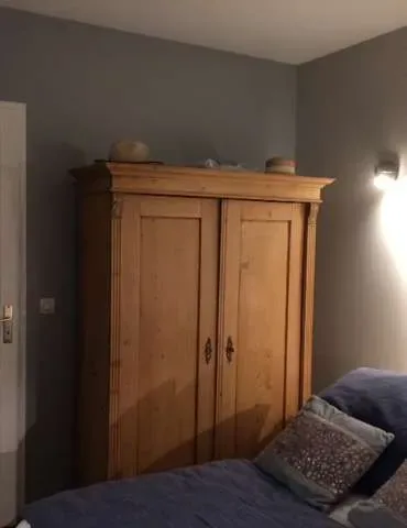 Chambre avec armoire en bois et lit