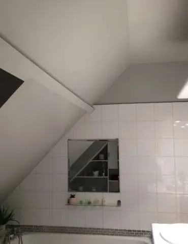Salle de bain avec baignoire, lavabo et miroir