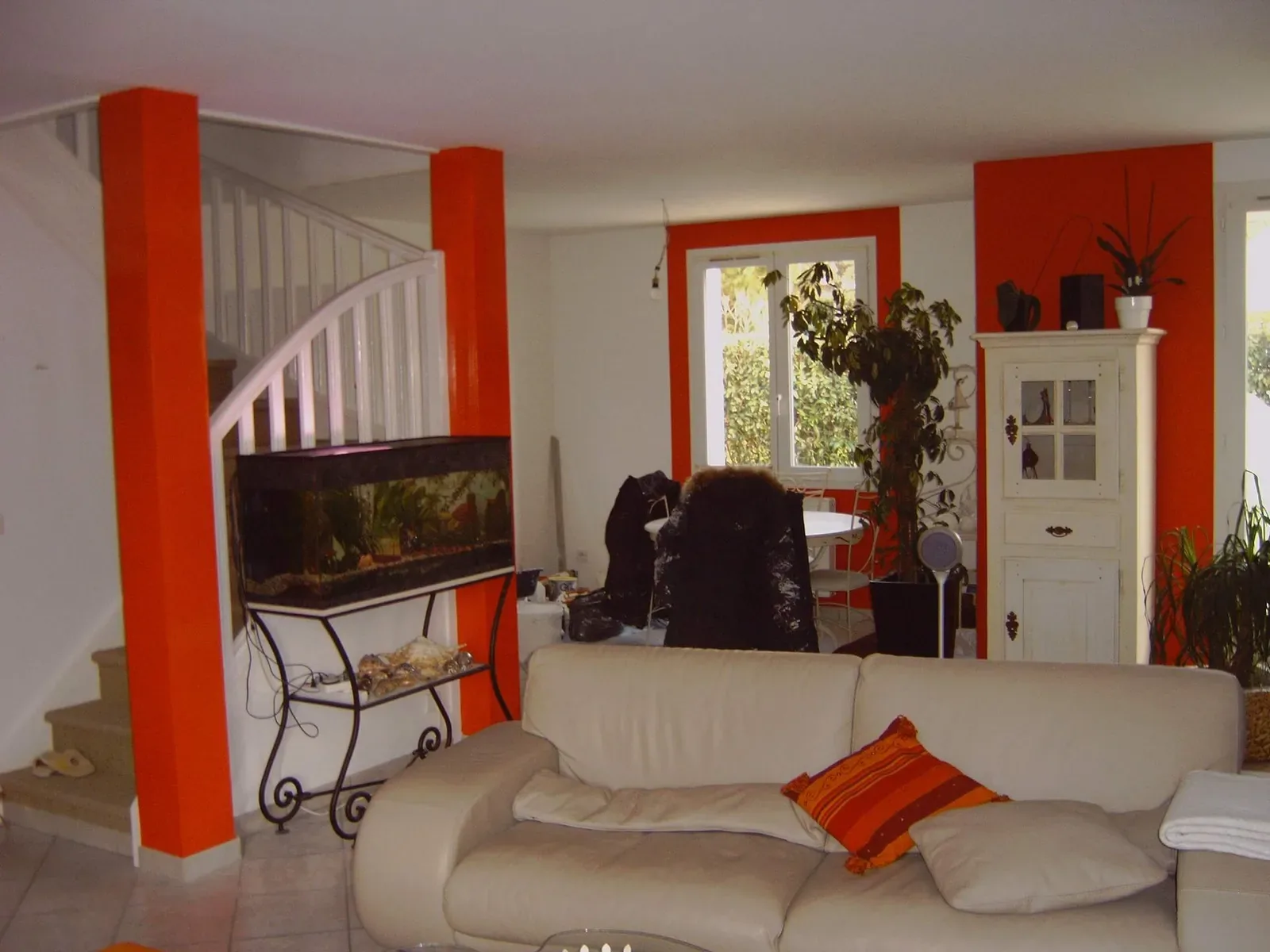 Salon avec canapé blanc et murs orange